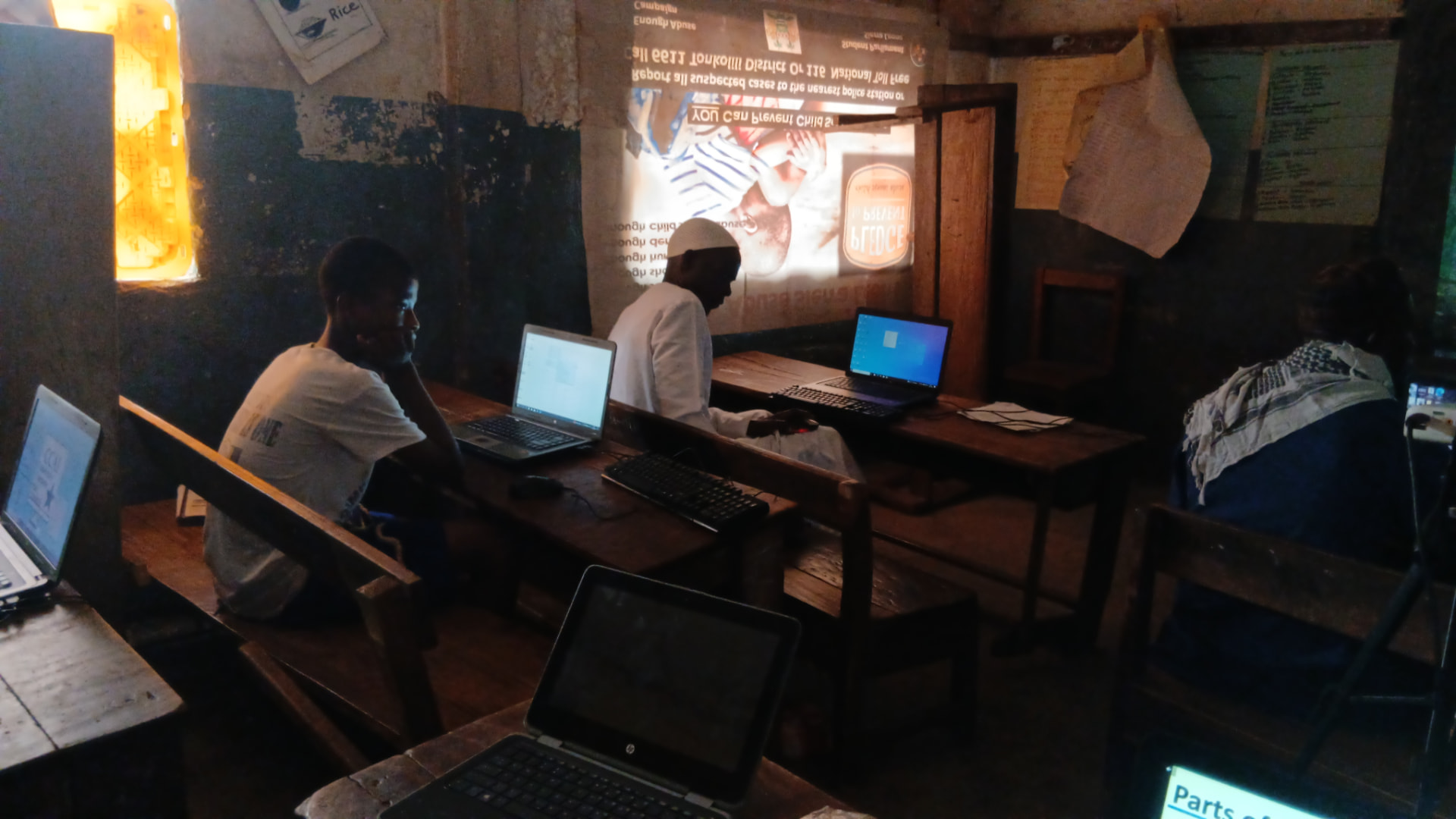 A projector-lit classroom where learners study online safety and child protection content