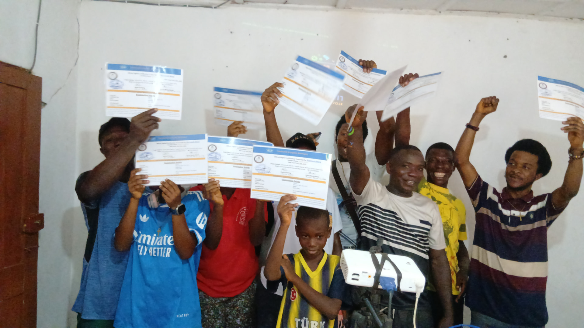 Graduates of a CCAP course celebrating while holding up their Microsoft Word certification transcripts