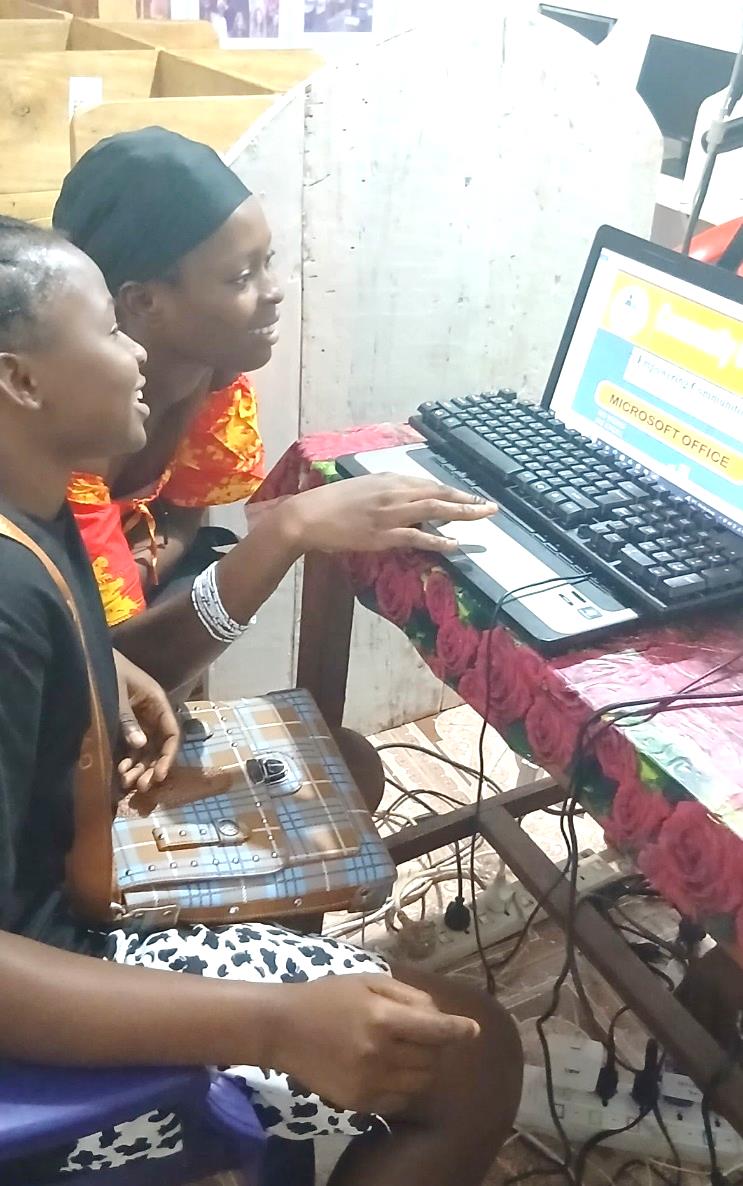 Two young learners working together on a laptop during a Microsoft Office session